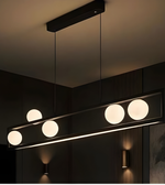 Modern pendant light fixture with four round lights on a dark ceiling.