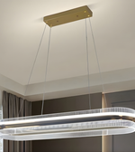 Modern pendant light fixture hanging from the ceiling in a room with neutral decor.