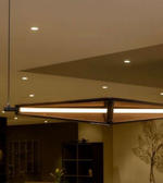 Modern pendant light fixture hanging from a ceiling in a room with neutral tones.