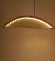 Gold pendant light fixture against a warm-toned wall.