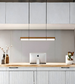 Modern kitchen with wooden countertop, white cabinets, and a hanging light fixture.