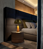 Modern bedroom with a bed, nightstand, and decorative lamp.