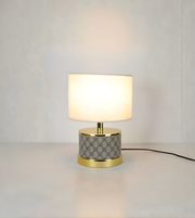 Table lamp with geometric patterned base on a plain background