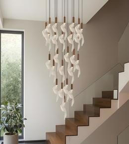 Modern chandelier hanging above a staircase with a window in the background