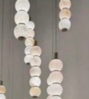 Chandelier with round, beige and white lampshades on a neutral background