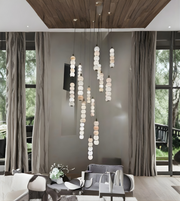Modern living room with a stylish chandelier, gray sofa, and large windows.