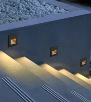 Modern outdoor fire pit with built-in lights on a concrete patio.