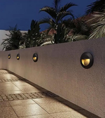 Outdoor wall lights on a concrete wall with palm trees in the background