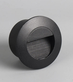 Round black outdoor light fixture on a gray background