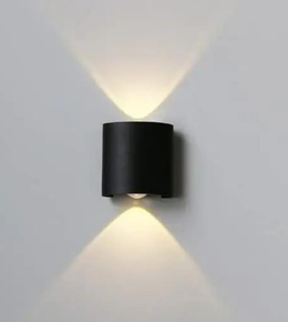 Black wall-mounted light fixture on a gray wall