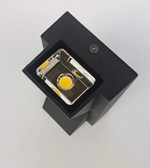 Small camera-like device in a black box on a light gray background