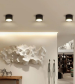 Modern interior design with ceiling lights, abstract wall sculpture, and decor items.