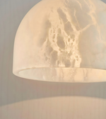 Close-up of a textured beige pendant light against a neutral background