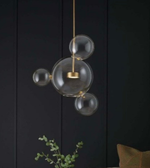 Modern pendant light with glass bubbles against a dark wall