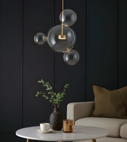 Modern interior with a bubble pendant light, table, and chair against a dark paneled wall.