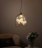 Pendant light fixture with glass shade in a dimly lit room.