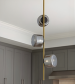Modern pendant light fixture with glass shades and gold accents in a kitchen setting.