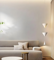 Modern living room with a gray sofa, small table, and pendant lights.