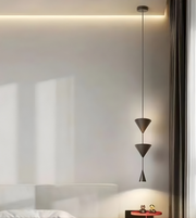 Modern pendant light fixture hanging from a ceiling in a minimalistic room.