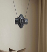 Modern black pendant light hanging against a neutral wall.