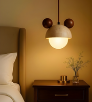 Pendant light fixture above a wooden nightstand with decorative items in a bedroom setting.