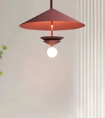 Modern pendant light with a red shade on a neutral background