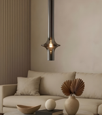 Modern pendant light hanging above a beige sofa in a living room setting.
