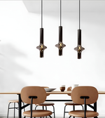 Modern dining area with pendant lights and a table.