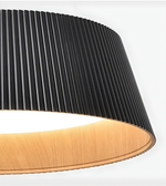 Close-up of a modern lamp with black pleated shade and wooden base on a white background