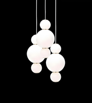 Modern pendant light with white glass spheres on a black background