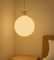 Spherical pendant light in a bedroom setting with warm lighting