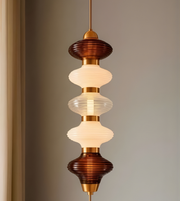 Decorative pendant light with tiered glass shades on a neutral background