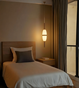 Bedroom with wooden headboard, white bedding, and pendant light.