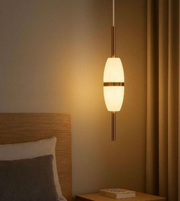 Pendant light fixture in a bedroom setting with warm lighting.
