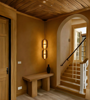 Narrow hallway with wooden bench, wall-mounted light fixture, and staircase.