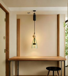 Modern pendant light hanging above a wooden desk in a minimalistic room.
