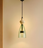 Modern pendant light with green glass shade on a beige background
