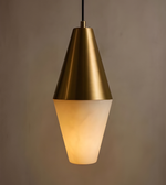 Gold pendant light with a beige glass shade on a brown background