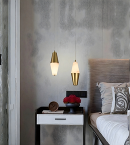 Modern bedroom with gold pendant lights, nightstand, and bed.