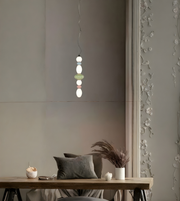 Modern pendant light hanging above a wooden table with decorative elements.
