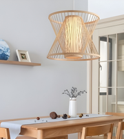 Wooden pendant light hanging above a dining table with a neutral background