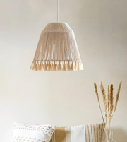 Beige pendant lamp hanging above a white sofa with a neutral background