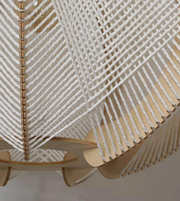 Close-up of a woven chair with a geometric pattern on a plain background