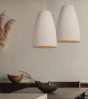 Two pendant lights hanging above a dining table with decorative elements.