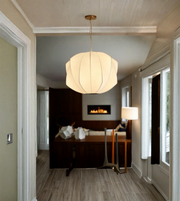 Modern pendant light hanging in a hallway with a bedroom in the background