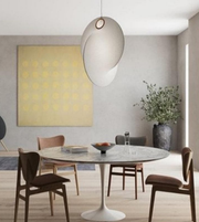 Modern dining room with a round marble table and wooden chairs.