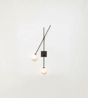 Sculptural wall sconce with angled arm and dual ambient light sources