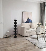 Black sculptural floor lamp beside a modern white sofa