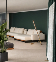 Leaning wooden floor lamp with LED light beside modern sofa