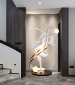 Illuminated dancer sculpture floor lamp with glowing spheres in a luxury modern interior